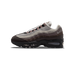 Lateral view of a Nike Air Max 95 sneaker in brown, grey, and mauve with a black visible air bubble sole unit.