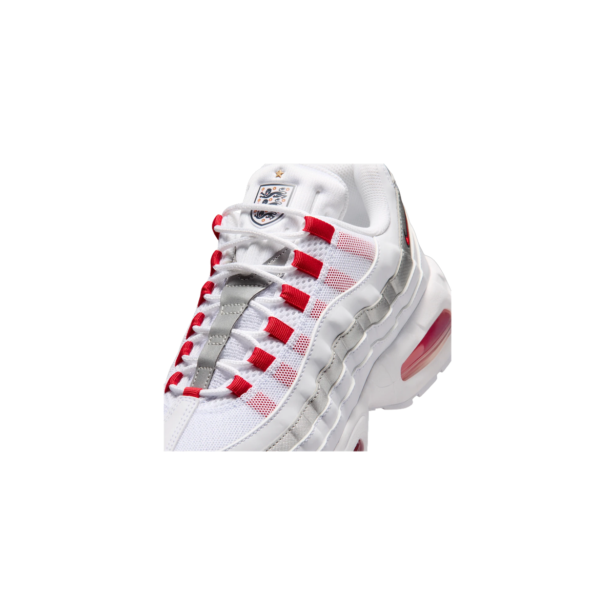 Close-up angled view of a white Nike Air Max 95 SE with red lace loops, silver ribbed side panels, an England crest patch on the tongue, and a red Air bubble sole unit visible at the heel.