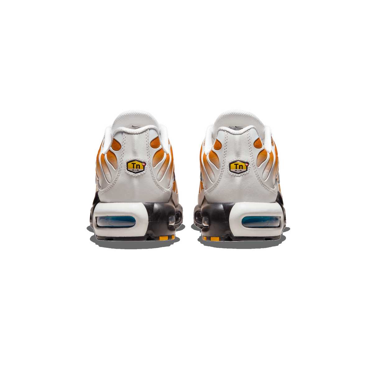 Rear view of a pair of Nike Air Max Plus sneakers standing side by side on a white background, showing white heel panels, orange and gold tuned overlays, Tn Air heel tabs, and visible blue Air units in the black and white midsoles.