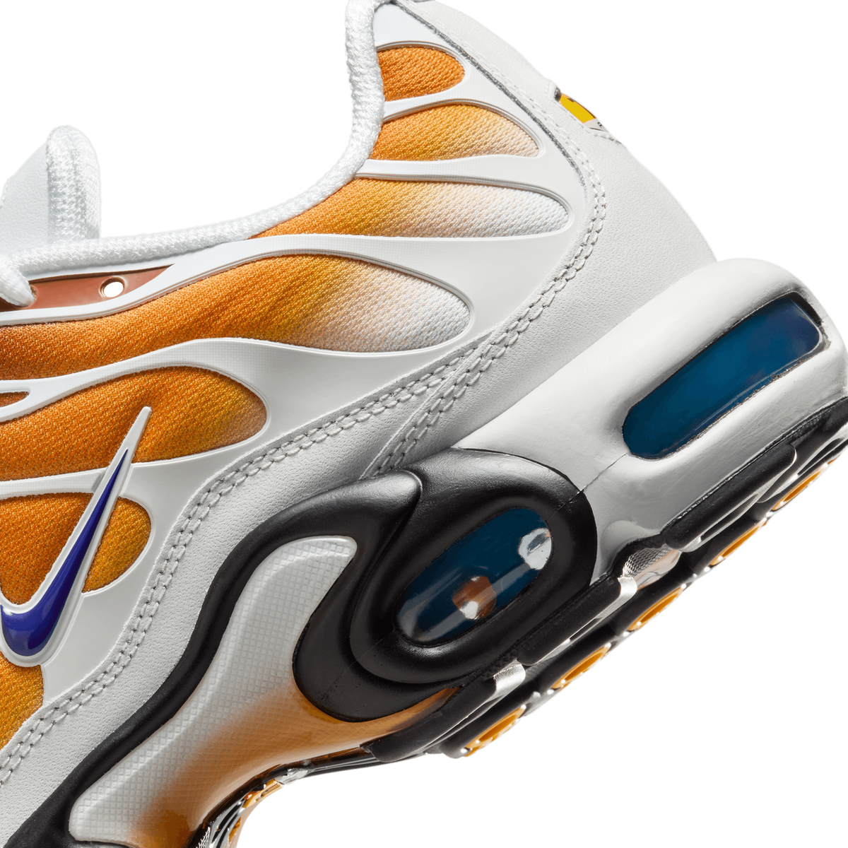 Close-up side detail of a white and orange Nike Air Max Plus sneaker showing the orange mesh panels, a blue Swoosh logo, and a blue Air unit in the heel with black and yellow accents along the sole.