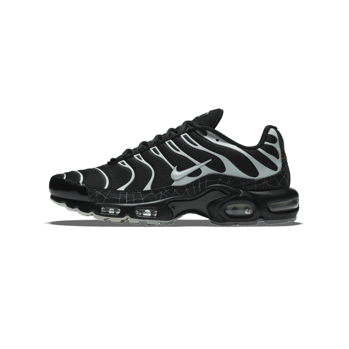 Side view of a black Nike Air Max Plus sneaker with gray swoosh overlays, a spider web-patterned toe box, and visible Air cushioning in the heel and midfoot.