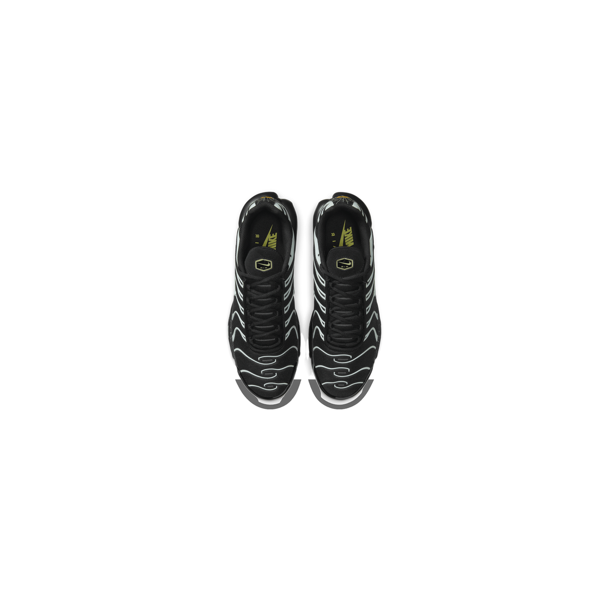 Top-down view of a pair of black Nike Air Max Plus sneakers with white wavy overlay stripes and a spider web pattern on the heel tabs, facing opposite directions with laces visible and Nike Air logo on the tongue insole.