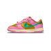 Lateral view of a pink and gold Nike Dunk Low with a green swoosh, cream midsole, and pink outsole, toe pointing left