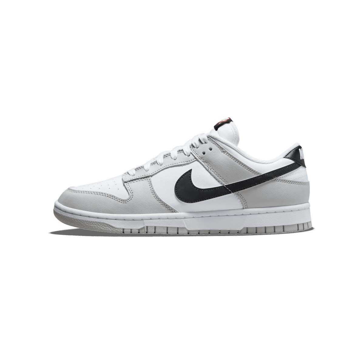 Lateral view of a grey and white Nike Dunk Low sneaker with a black swoosh, white laces, and a lottery ticket graphic on the heel pull tab, toe pointing left.