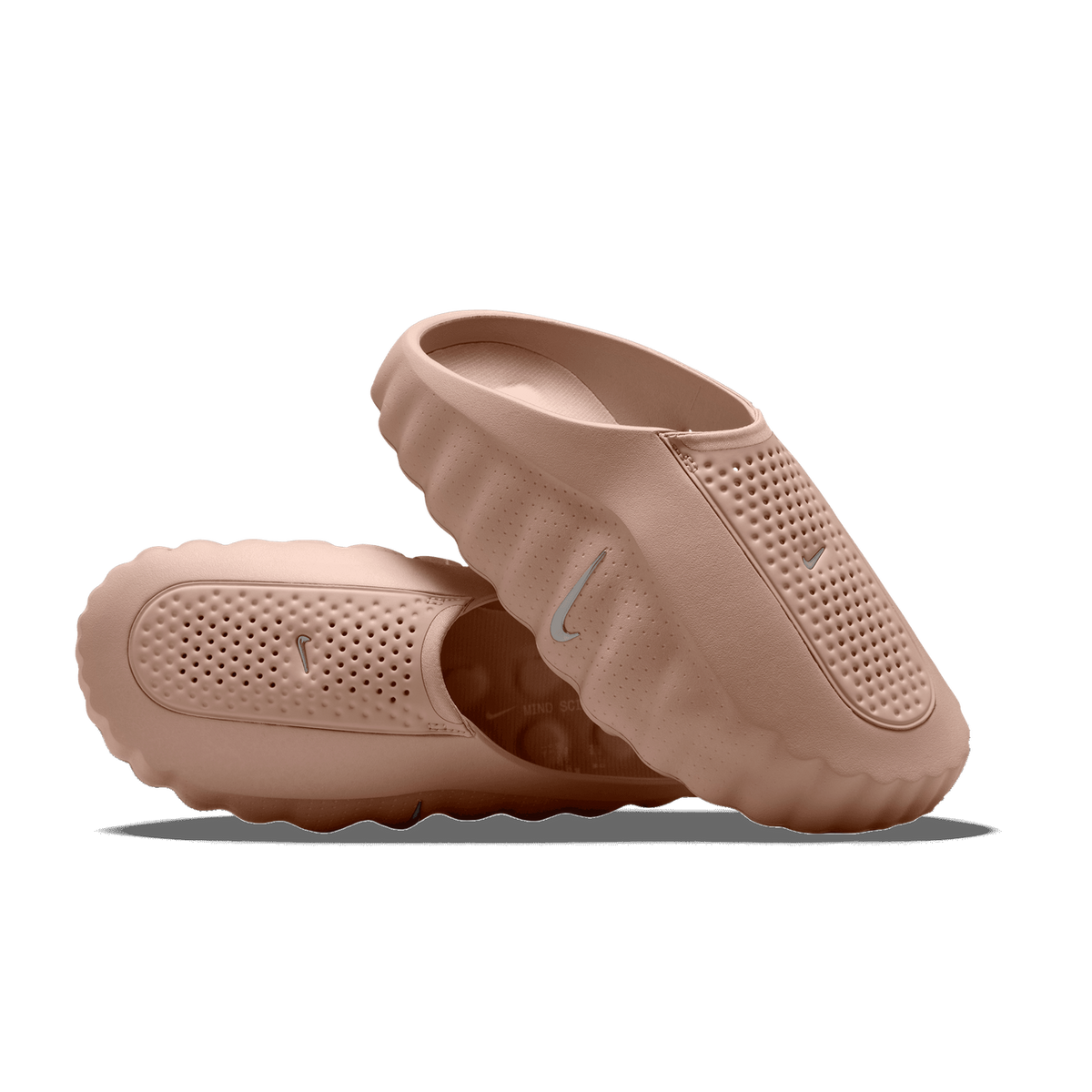 Pair of brown perforated Nike Mind 001 slip-on shoes, one upright showing the side Swoosh and one resting on its side showing the outsole tread