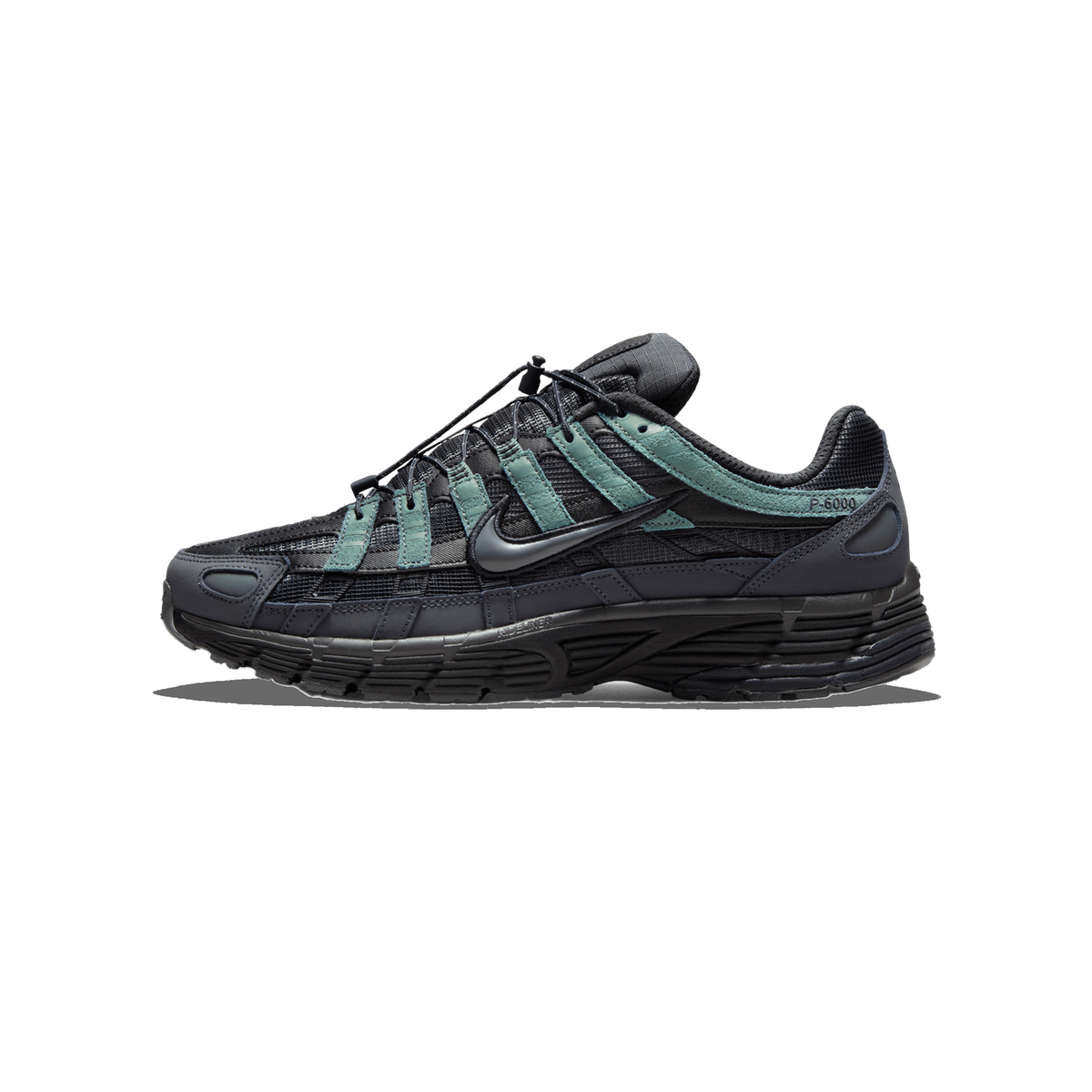 Side profile of a Nike P-6000 sneaker in anthracite grey and black with sage-green suede overlays, toe pointing left, showing the Swoosh logo, a 'P-6000' label on the heel panel, and a bungee lace-lock system.
