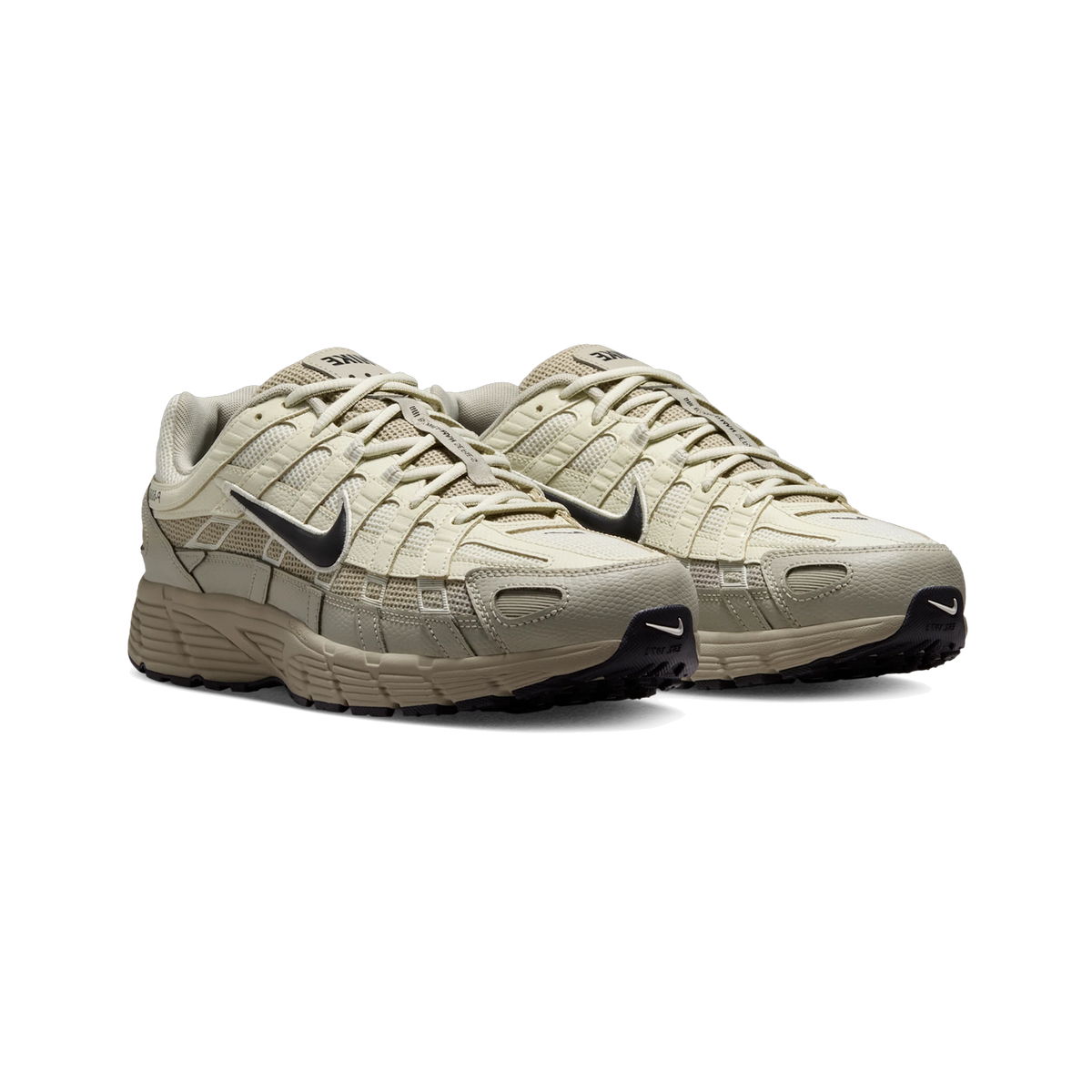 Front-angled view of a pair of Nike P-6000 sneakers in beige and cream with dark navy swoosh logos and a chunky tan outsole.
