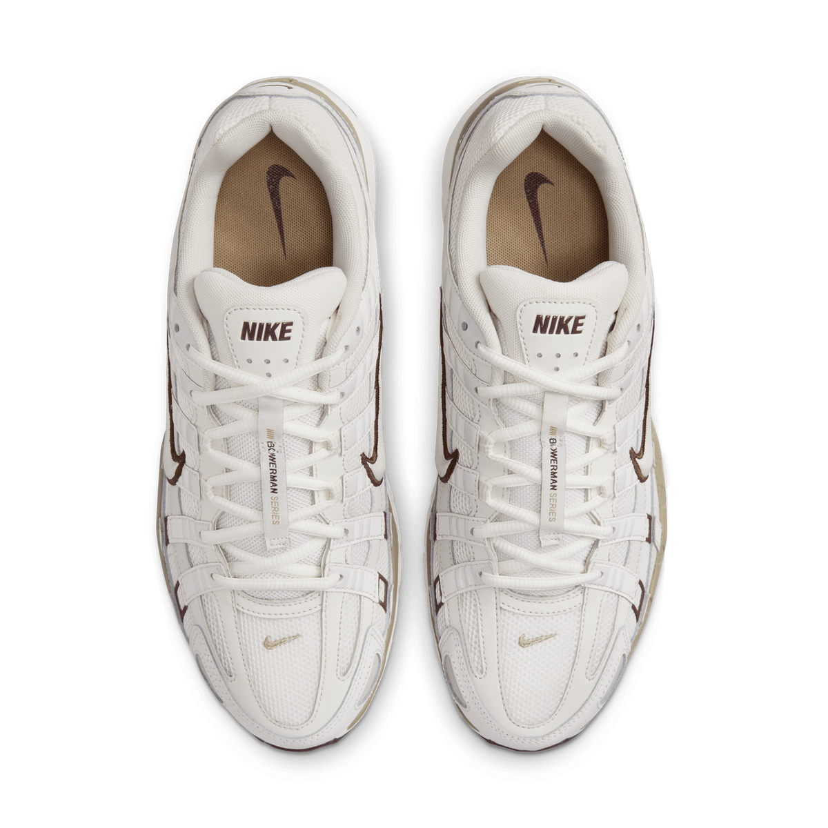 Top-down view of a pair of cream-white Nike P-6000 sneakers side by side, showing the tan insoles with brown Nike swoosh logos, white laces, brown swoosh outlines on the upper, and the Bowerman Series tongue label.