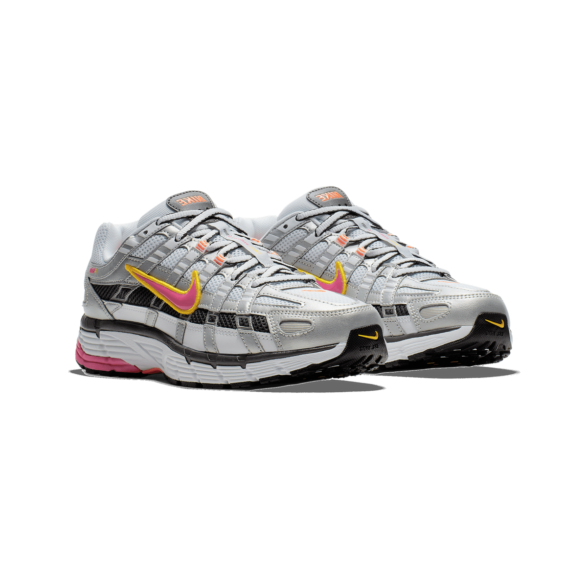 Front-angled view of a pair of Nike P-6000 sneakers in white and silver with pink Swoosh logos outlined in yellow and a black and pink midsole.