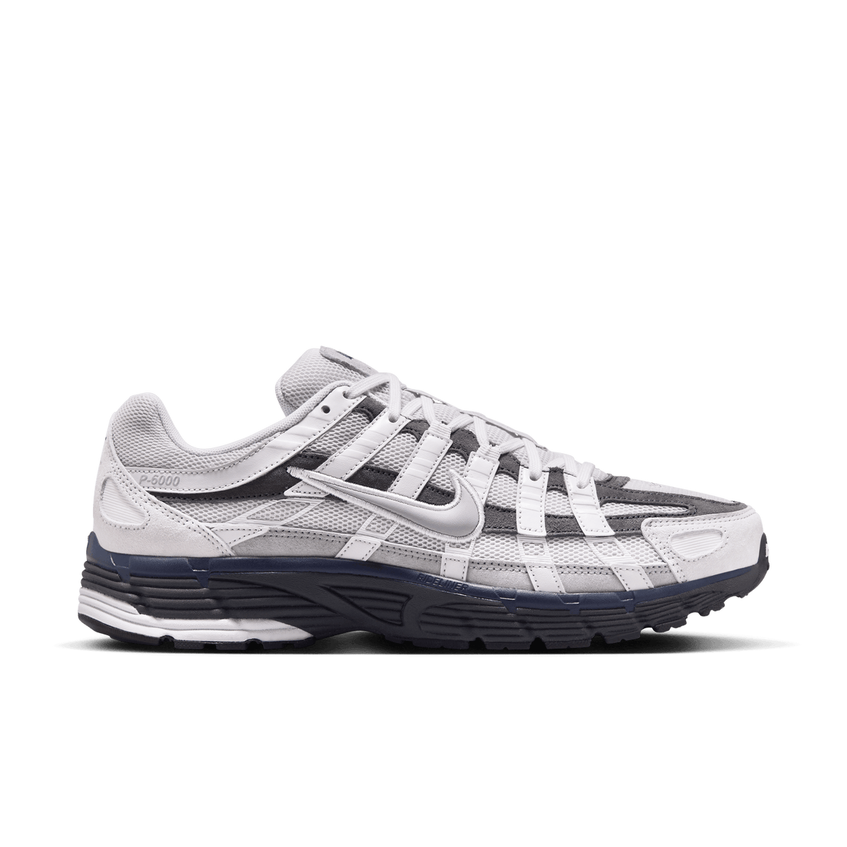 Lateral view of a grey and dark grey Nike P-6000 sneaker with white laces, mesh panels, and a navy and black layered midsole.