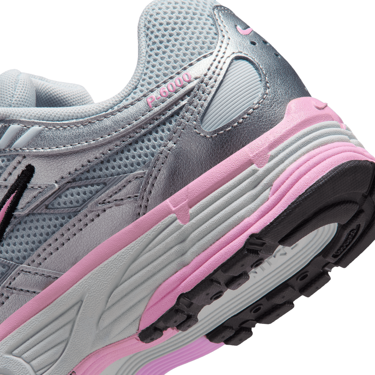 Close-up angled view of a Nike P-6000 sneaker's heel showing grey mesh upper, metallic silver overlays, pink midsole stripe, and black lugged outsole with P-6000 text on the heel tab.