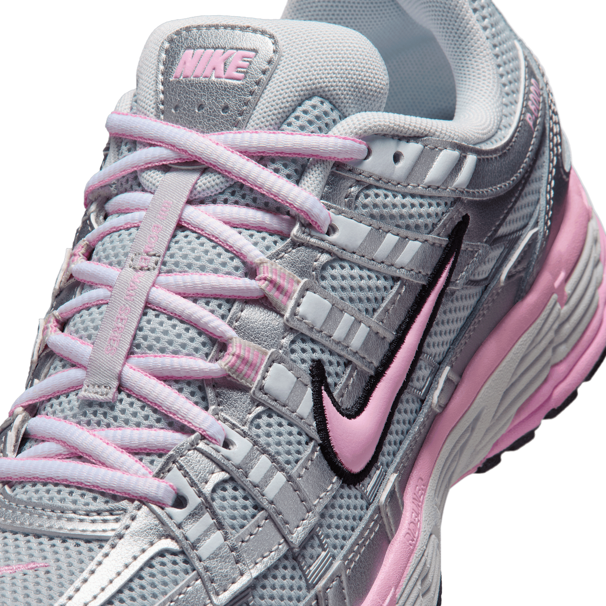 Close-up top view of a silver and pink Nike P-6000 sneaker showing the pink swoosh logo, mesh upper, laces, and tongue branding