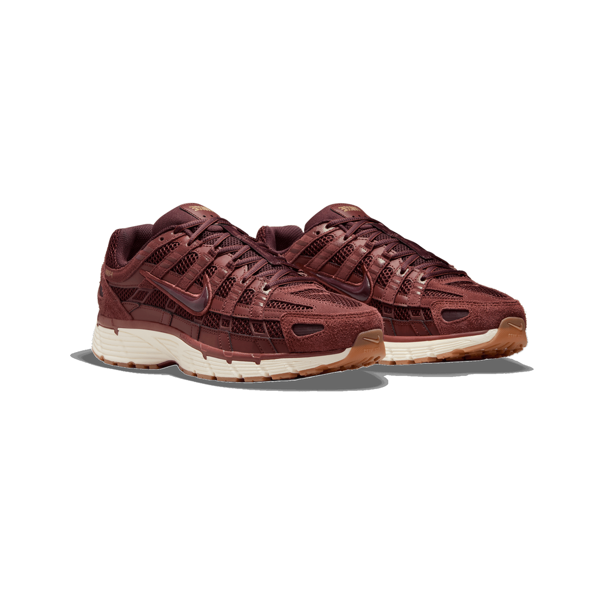 A pair of burgundy-brown Nike P-6000 sneakers shown side by side at a three-quarter angle, with mesh and suede panels, a cream midsole, and gum rubber outsoles.