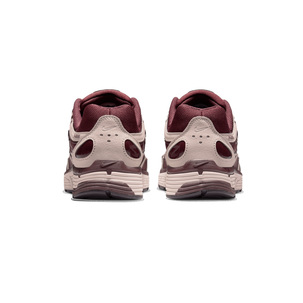 Rear view of a pair of burgundy and light taupe Nike P-6000 sneakers standing side by side, showing the heel tabs, the P-6000 branding on the heel, and the layered sole edges.