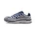 Widok z boku szarego sneakersa Nike P-6000 z granatowymi i niebieskimi akcentami, srebrnym swooshem, masywną białą podeszwą pośrednią i widocznym napisem 'P-6000' przy pięcie.
