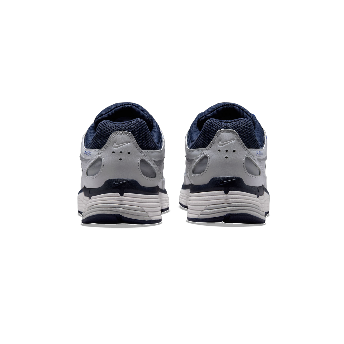 Rear view of a pair of gray Nike P-6000 sneakers with navy blue heel tabs, mesh lining, and white layered soles.