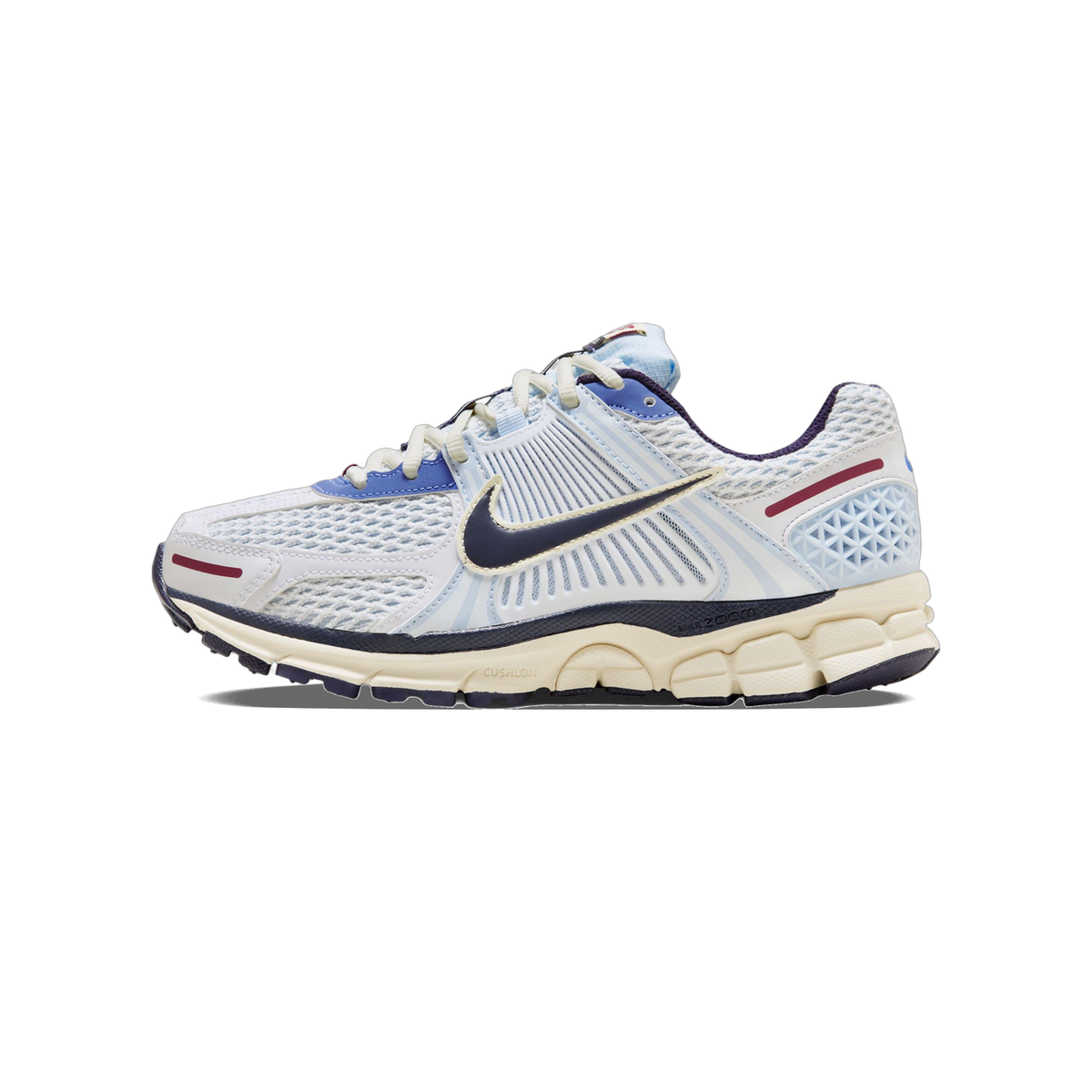 Side view of a white Nike Zoom Vomero 5 sneaker with light blue mesh panels, navy swoosh, maroon accent stripe, and a cream chunky midsole