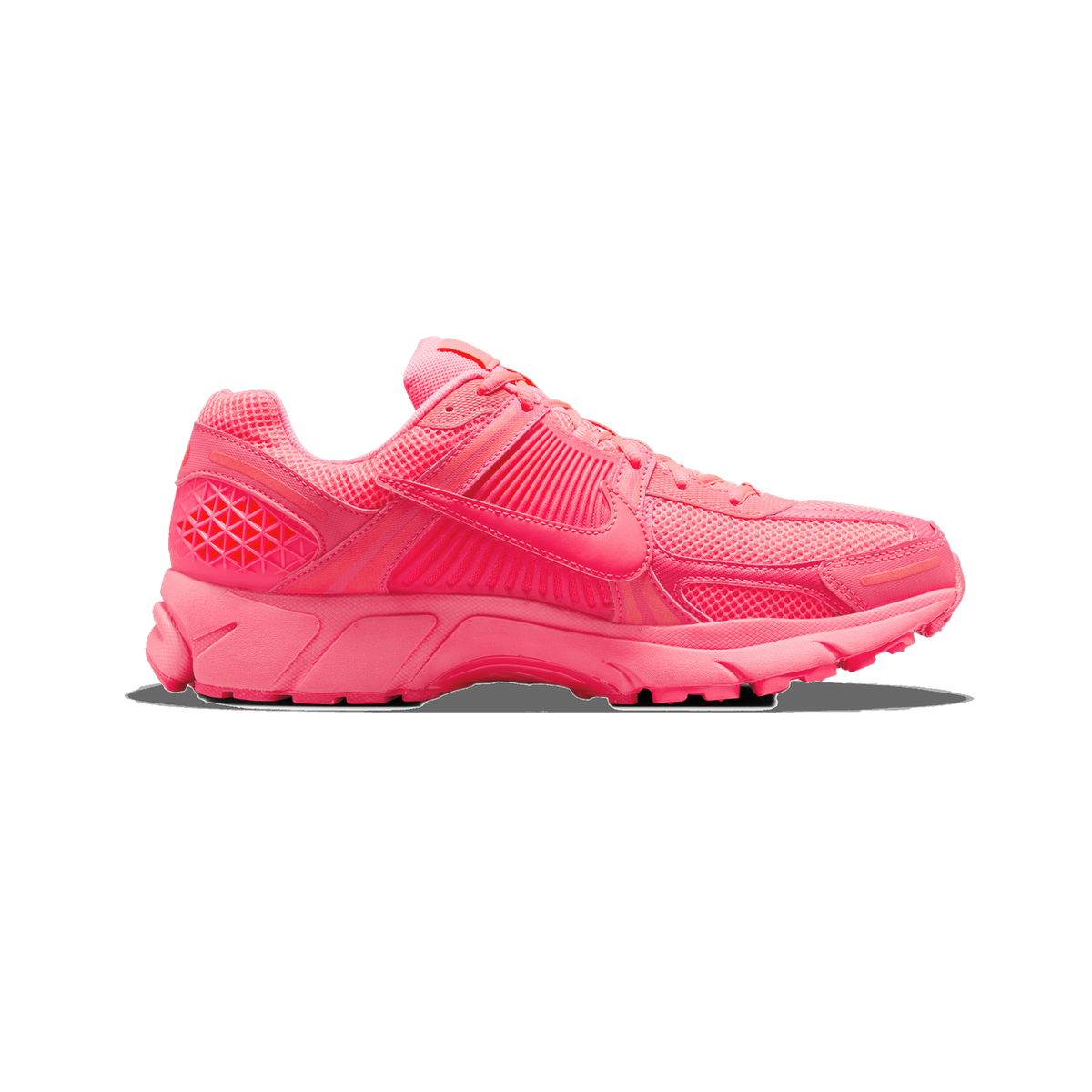Side profile of a single pink Nike Zoom Vomero 5 sneaker with the toe pointing left, showing a pink mesh upper, a large Nike swoosh on the side, and a chunky pink sole.