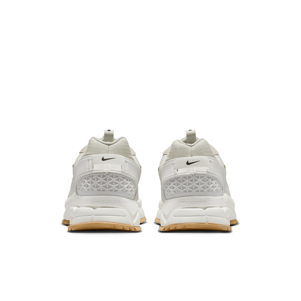 Rear view of a pair of Nike Zoom Vomero 5 sneakers in sail and light stone with gum rubber outsoles and textured heel panels featuring the Nike Zoom logo.
