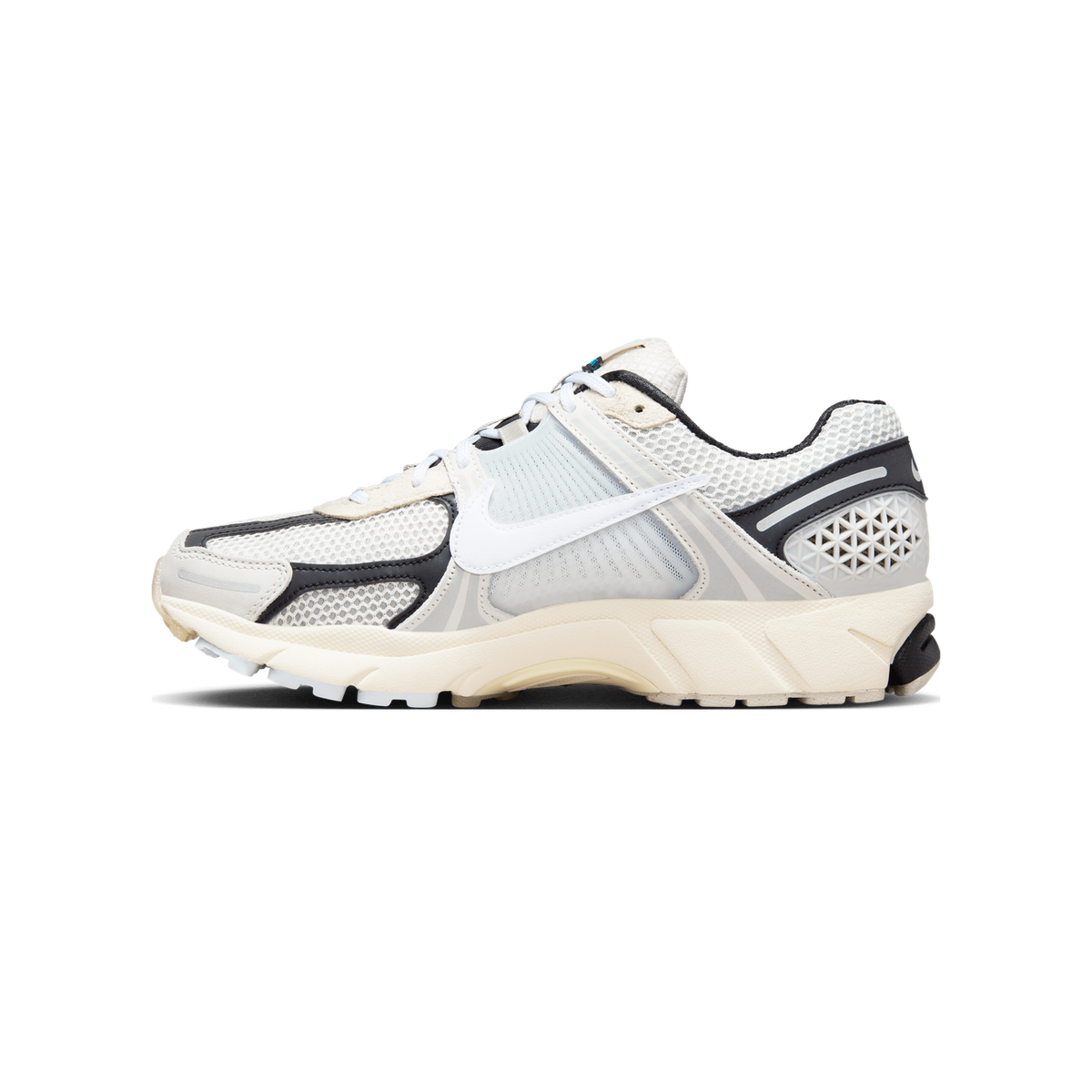 Side view of a white, grey, and black Nike Zoom Vomero 5 running shoe with a cream midsole and large white swoosh.