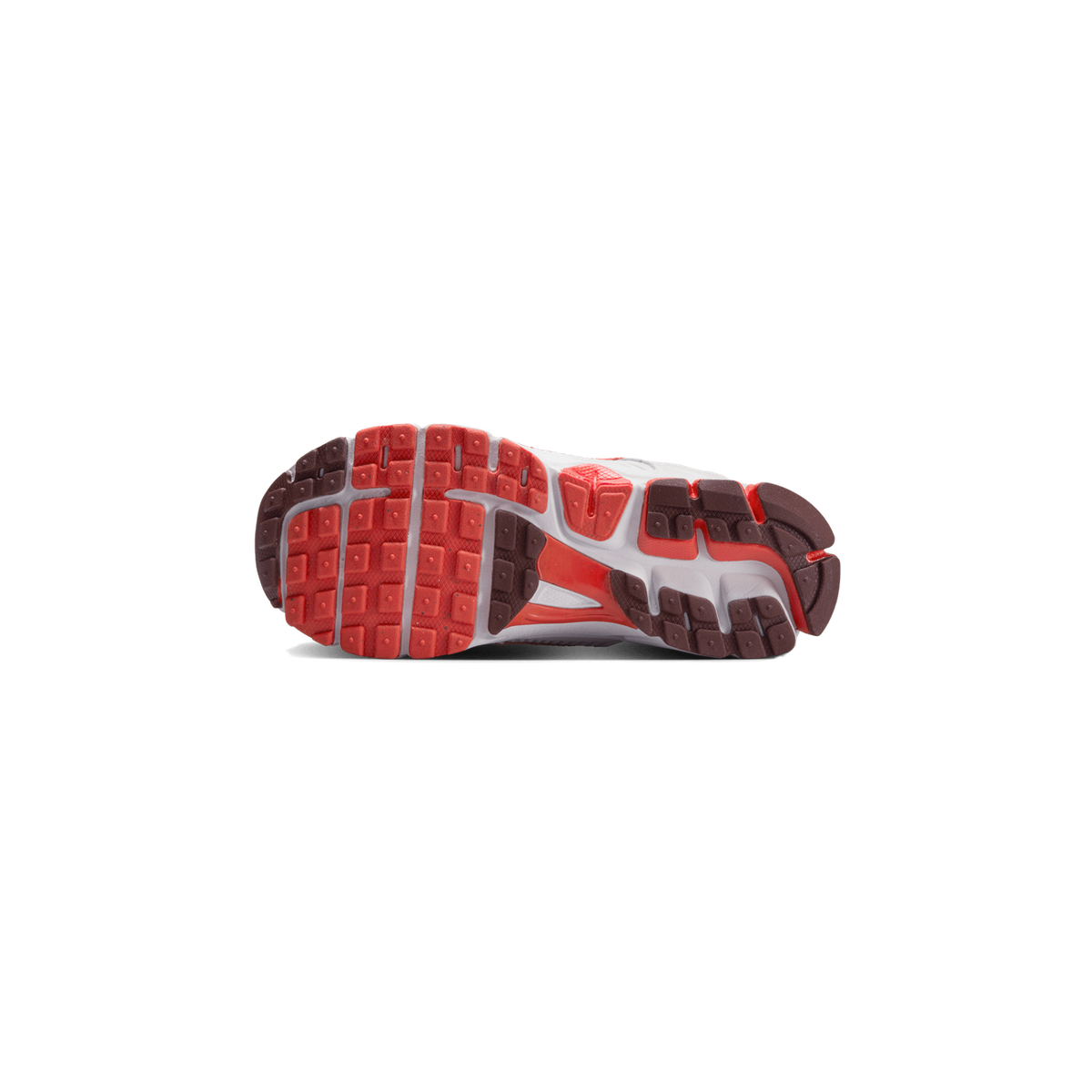 Underside of a sneaker showing a red and dark brown lugged rubber outsole with a white midsole, photographed against a plain white background.