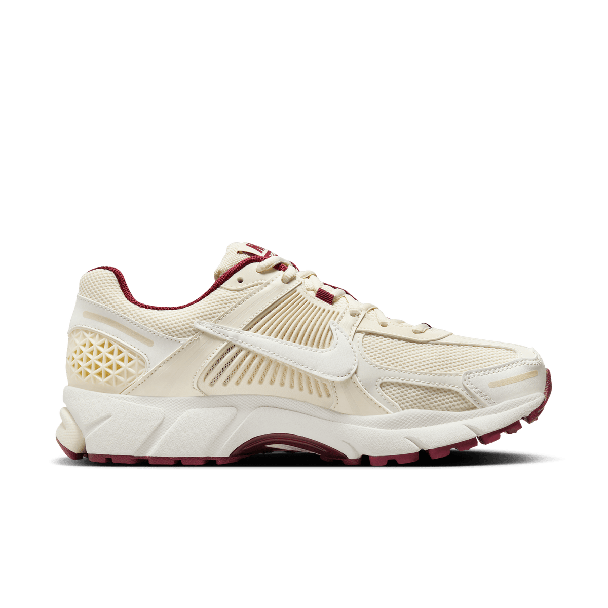 Right lateral view of a cream Nike Zoom Vomero 5 sneaker with a white swoosh and dark maroon accents on the lining and outsole
