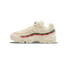 Side profile of a cream-colored Nike Air Max 95 sneaker with the toe pointing left, showing a red and green UNDEFEATED stripe along the side and a silver Swoosh logo.