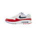 Lateral view of a white and red Nike Air Max 1 golf shoe with a navy swoosh lined with white stars and a visible Air sole unit, toe pointing left