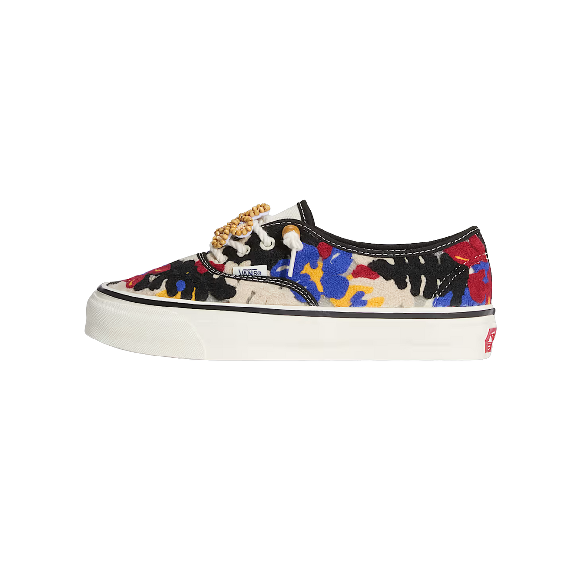 Side view of a Vans Authentic sneaker with an embroidered floral pattern in black, red, blue, and yellow, wooden beads on the laces, and a white sole with the Vans side patch.