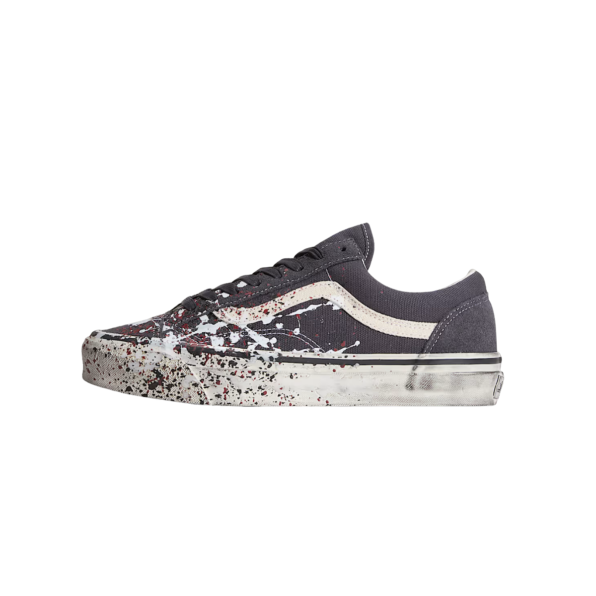 Side view of a charcoal grey Vans Old Skool sneaker with a cream side stripe and white, black, and red paint splatter across the toe box and sole.
