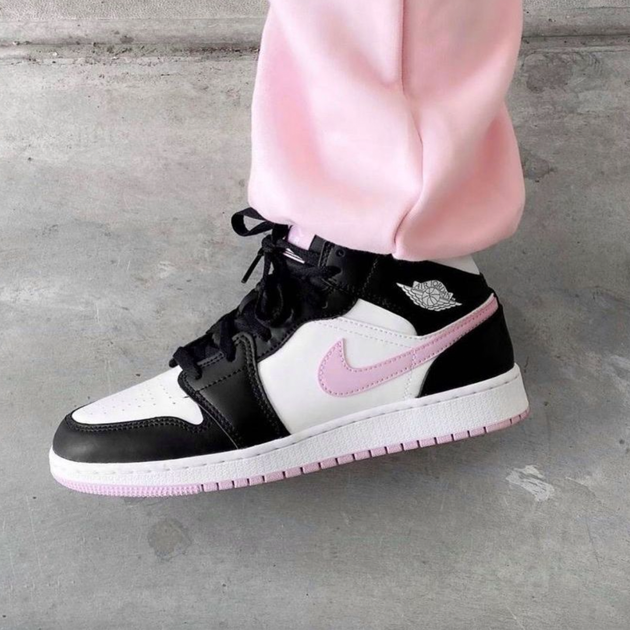 Air Jordan 1 Mid White Black Light Arctic Pink sneaker with leather upper soft pink accents available at The Attic
