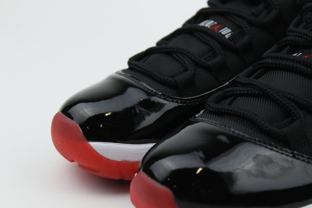 Air Jordan 11 Retro Low ‘Bred’ – iconic low-top basketball sneakers with a classic black and red colourway, premium patent leather upper, and cushioned sole, perfect for style and performance.