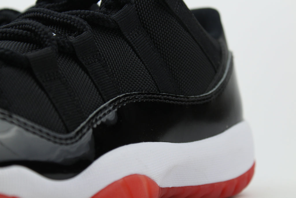 Air Jordan 11 Retro Low ‘Bred’ – iconic low-top basketball sneakers with a classic black and red colourway, premium patent leather upper, and cushioned sole, perfect for style and performance.