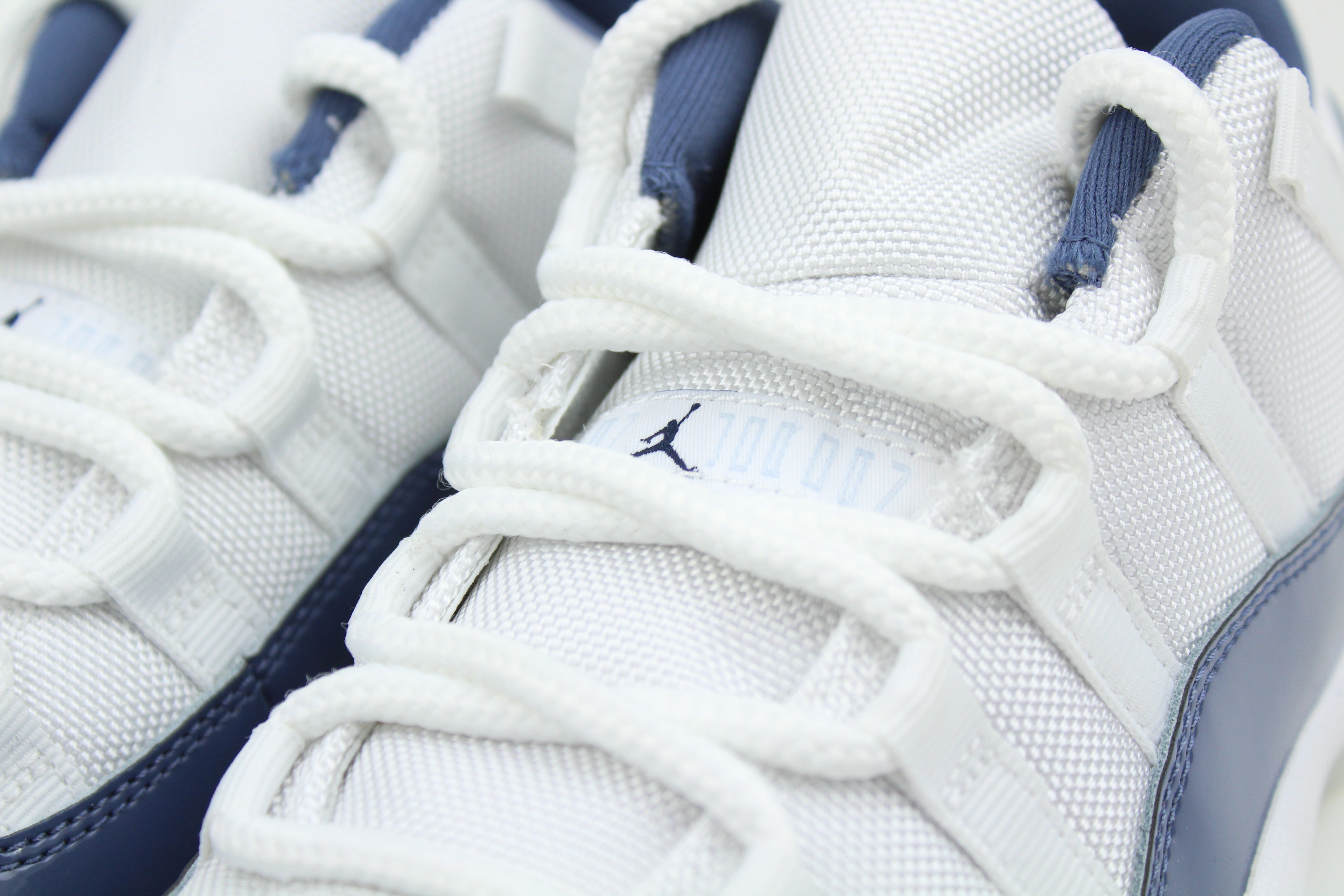 Air Jordan 11 Retro Low Diffused Blue sneakers side view, white leather with blue accents, iconic low-top basketball shoe, premium athletic footwear, stylish and collectible