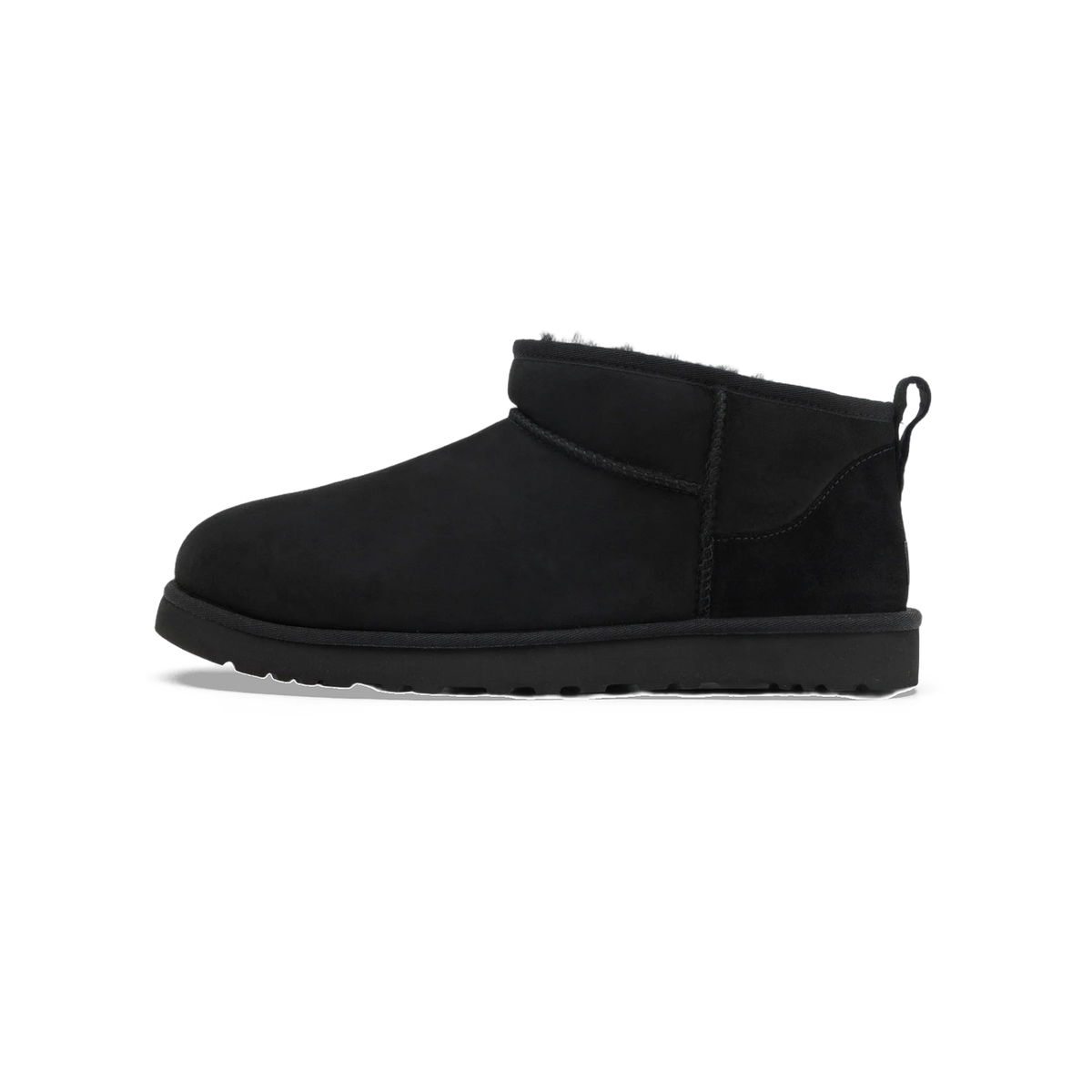 Side view of a black UGG Classic Ultra Mini ankle boot with pull-on heel loop and shearling lining visible at the collar