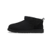 Side view of a black UGG Classic Ultra Mini ankle boot with pull-on heel loop and shearling lining visible at the collar