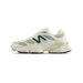 Left side view of a white and pale yellow New Balance 9060 sneaker with a dark green N logo and chunky two-tone sole.