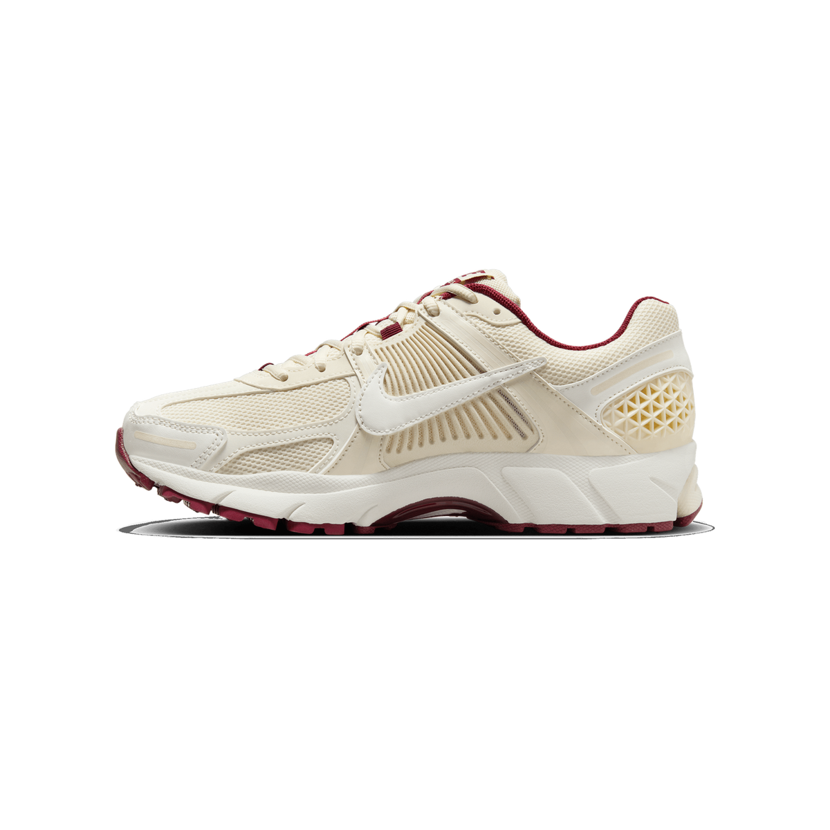Lateral view of a cream Nike Zoom Vomero 5 sneaker with white swoosh, burgundy lace eyelets and heel trim, and burgundy outsole details.