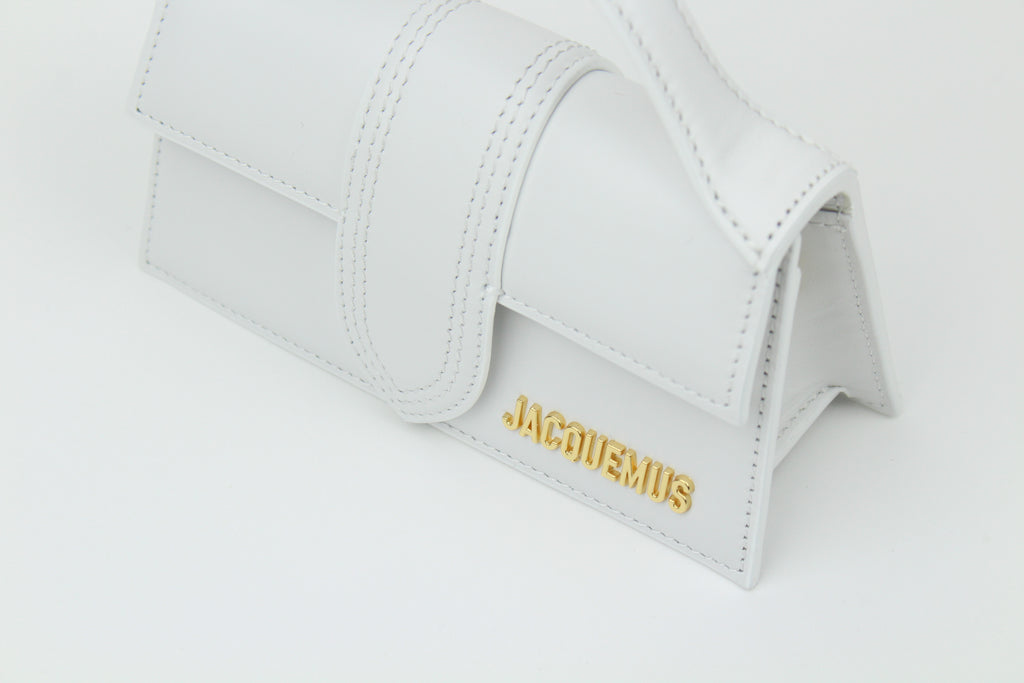 Discover the Jacquemus Le Bambino Top Handle Bag Small 'White' – a compact leather handbag with a sleek silhouette, versatile styling, and timeless minimalist elegance.