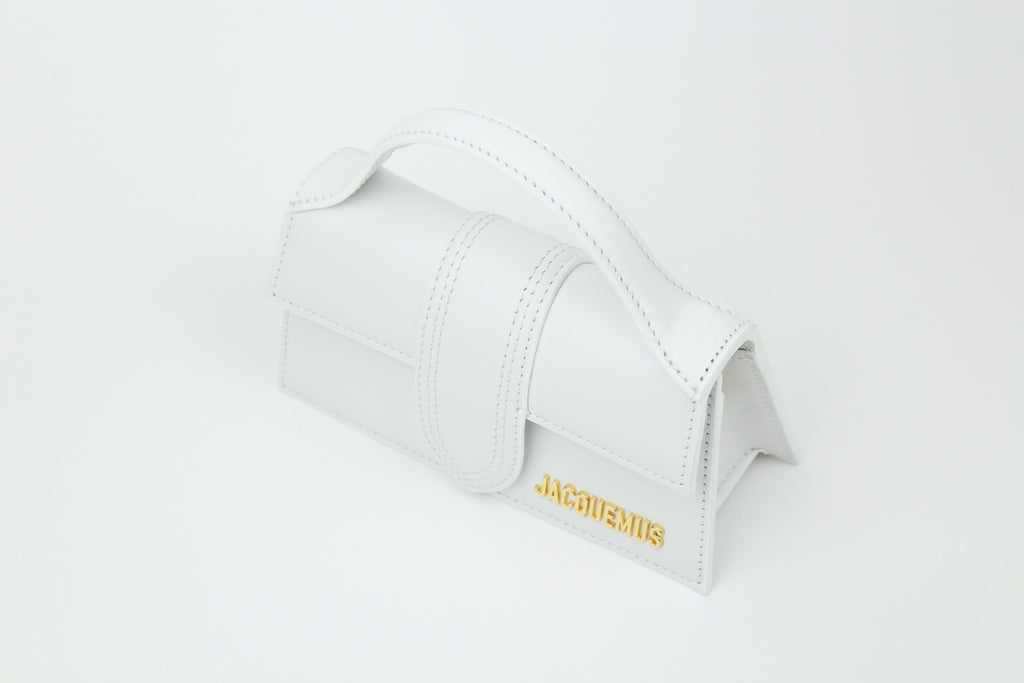 Discover the Jacquemus Le Bambino Top Handle Bag Small 'White' – a compact leather handbag with a sleek silhouette, versatile styling, and timeless minimalist elegance.