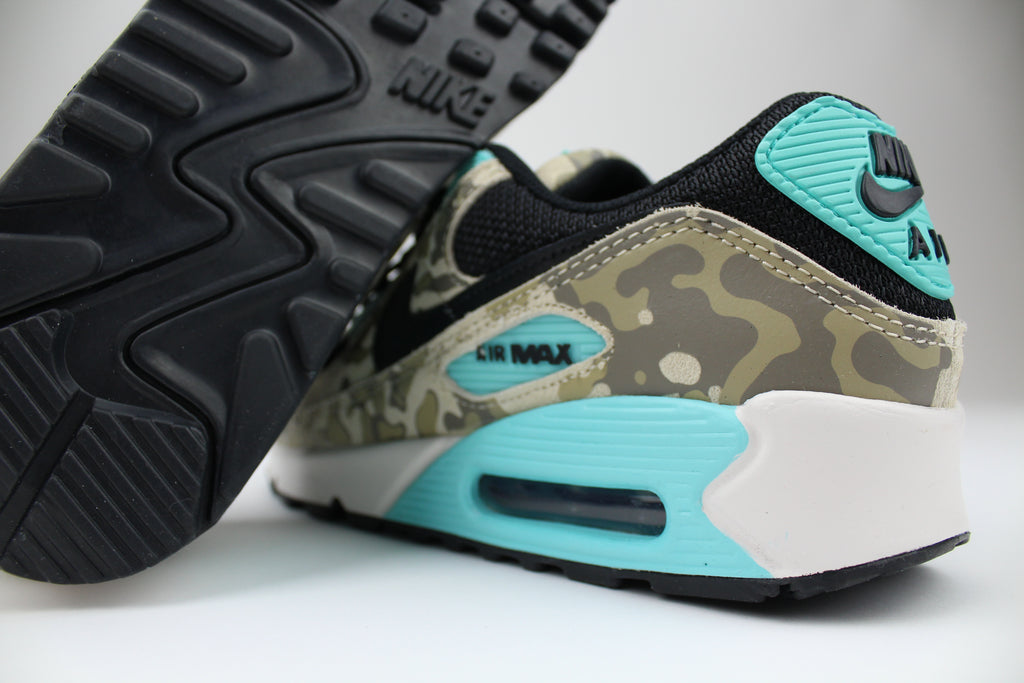 Nike Air Max 90 ‘Aurora Green’ from the 2025 Camo Pack with layered materials and bright green accents. Style with cargos and clean layers for rugged yet polished streetwear.