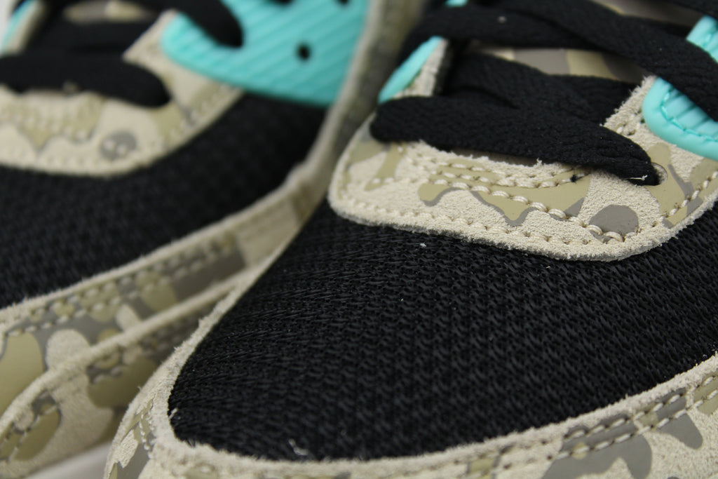 Nike Air Max 90 ‘Aurora Green’ from the 2025 Camo Pack with layered materials and bright green accents. Style with cargos and clean layers for rugged yet polished streetwear.