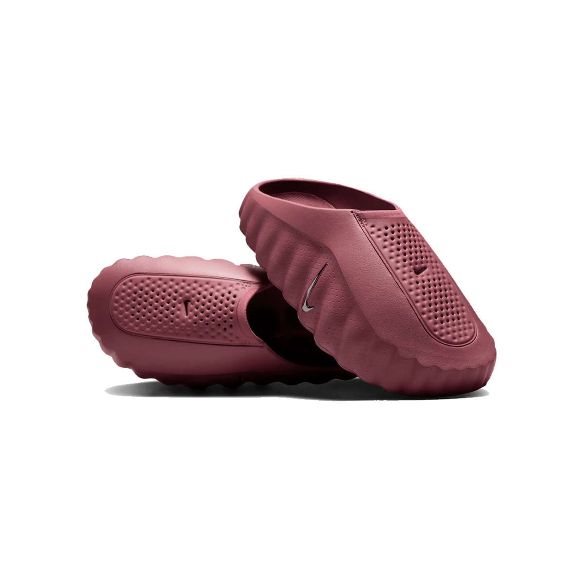 Et par mørkepink Nike Mind 001 sandaler med perforeret overdel og riflet yderåde, en vist stående og en liggende.