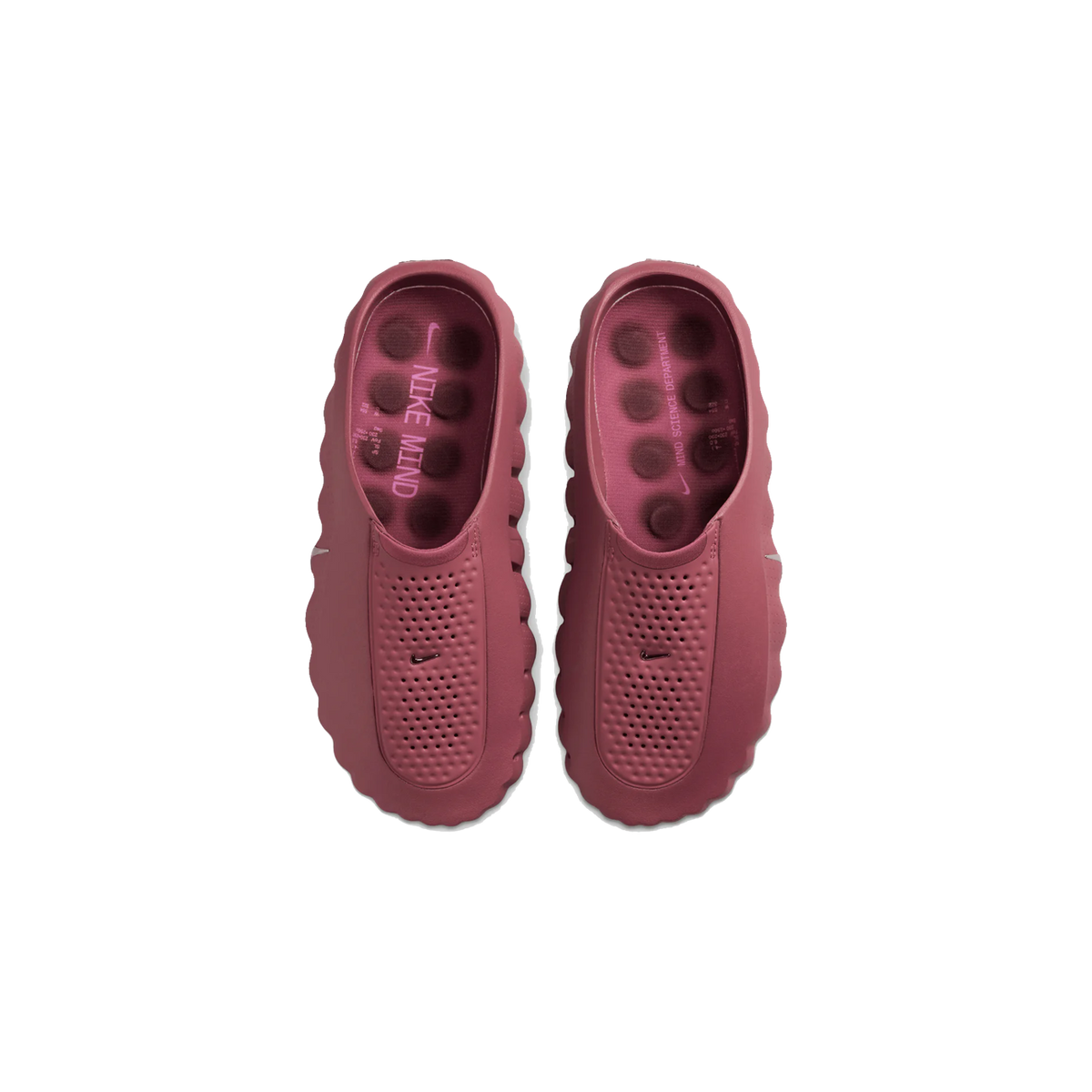 Set oppefra: et par støvet pink Nike Mind 001 slip-on træsko med perforeret overdel, buede sålekanter og strukturerede prikker på indlægssålen med teksten Nike Mind Science Department.