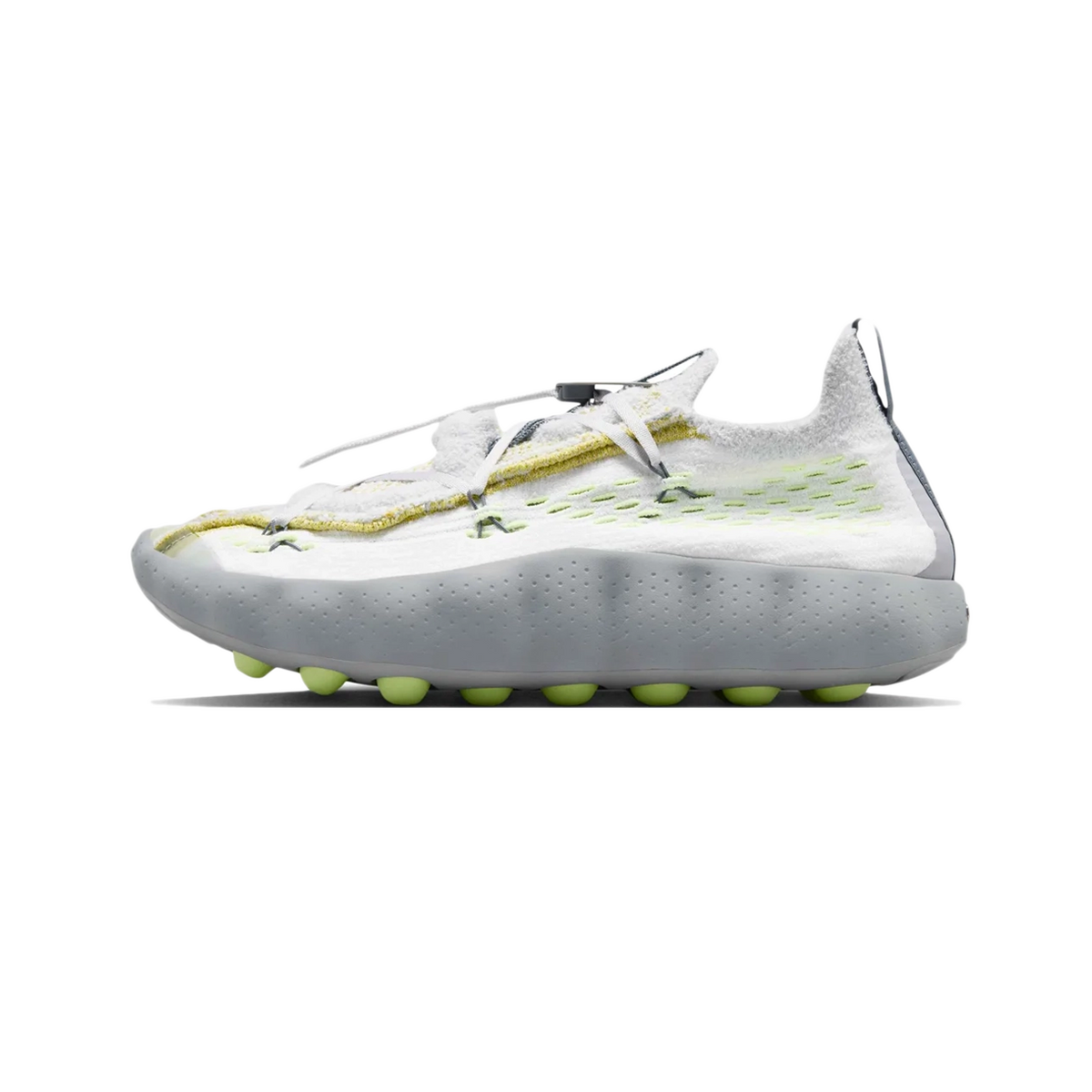 Side view of a white Nike Mind 002 Flyknit sneaker with textured fuzzy upper, grey heel panel, volt accents, and a nubbed grey outsole with volt-colored studs.