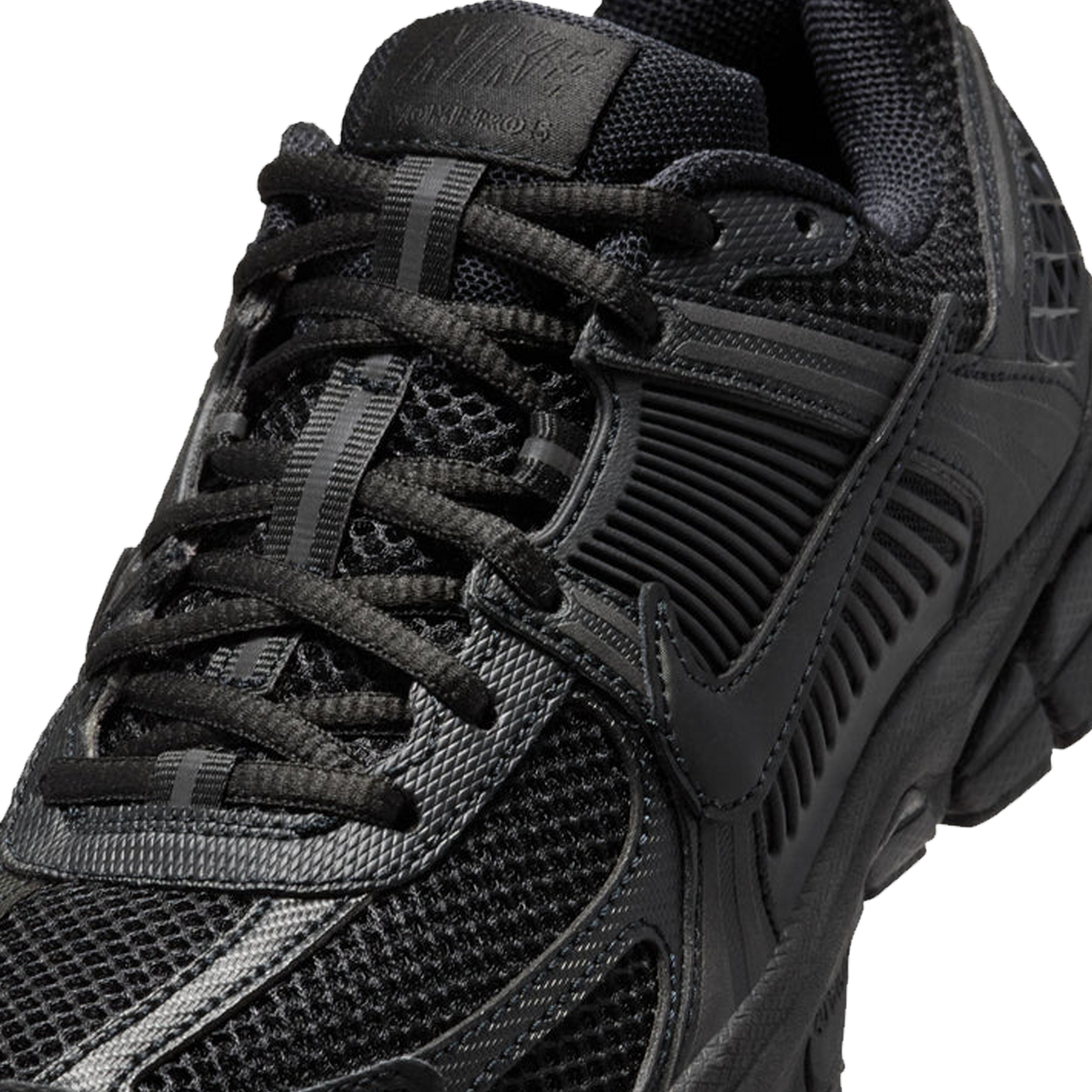 Nærbillede oppefra af en sort Nike Vomero 5 sneaker, der viser mesh overdelen, snørebånd, tungen med præget branding og swoosh logoet.